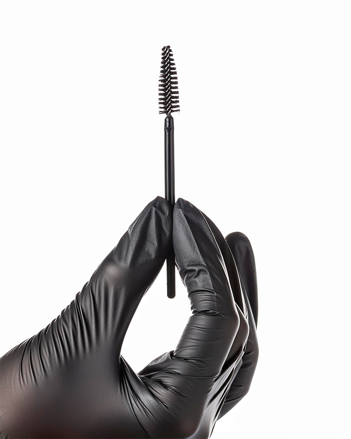 Firefly gere uma mão feminina segurando uma escovinha para cílios, a mão deve estar com uma luva 919
